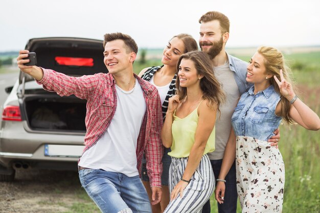 Grupo amigos, ficar, perto, a, carro estacionado, levando, selfie, ligado, telefone pilha