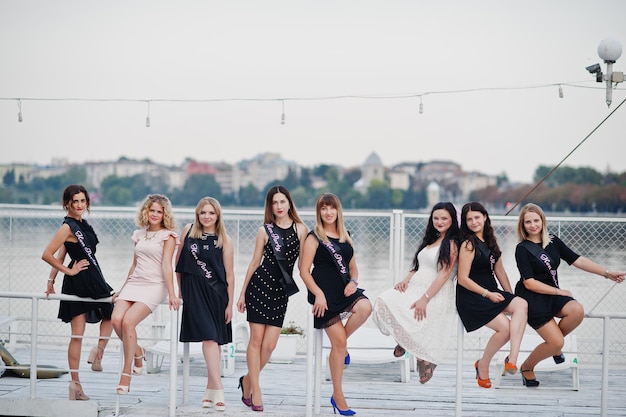 Foto grátis grupo de 8 meninas vestem preto e 2 noivas na festa de despedida no cais na beira da praia