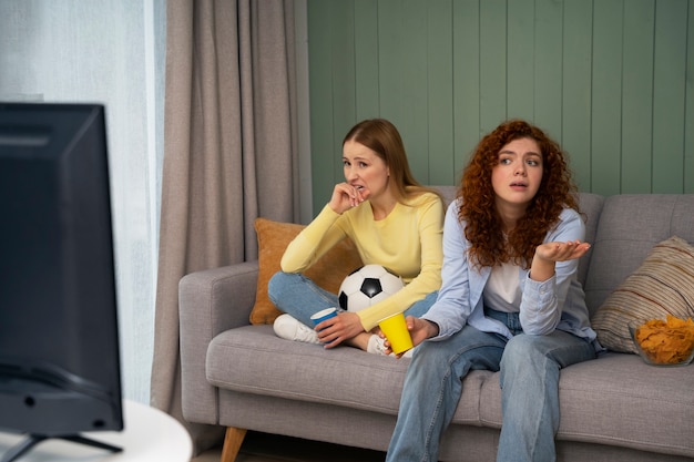 Foto grátis grupo de amigas em casa assistindo esportes juntas