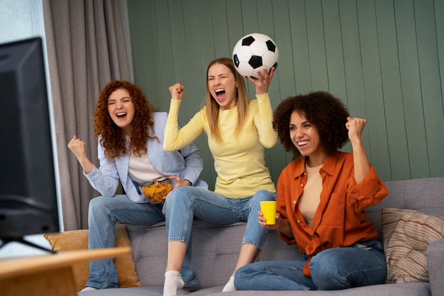 Grupo de amigas em casa assistindo esportes juntas