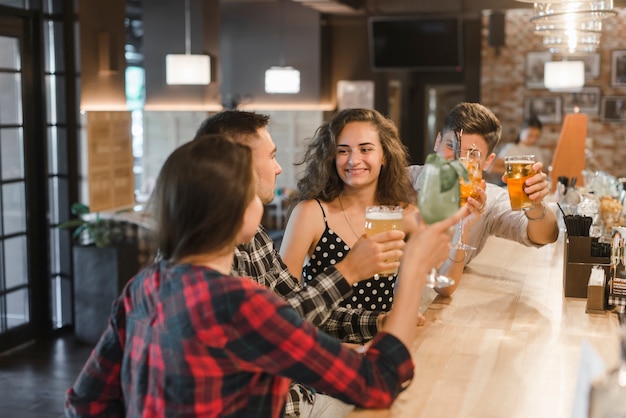 Foto grátis grupo de amigos alegres, desfrutando de bebidas no pub