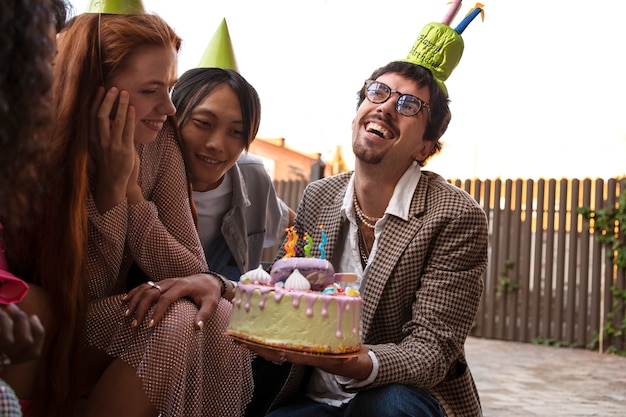 Grupo de amigos com bolo em uma festa de aniversário surpresa