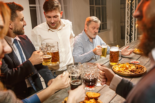 Grupo de amigos curtindo drinks à noite com cerveja