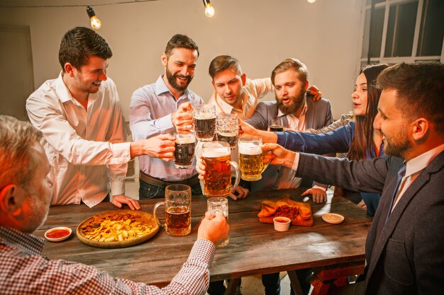 Grupo de amigos, desfrutando de bebidas à noite com cerveja