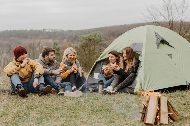 Grupo de amigos em viagem de inverno com tenda
