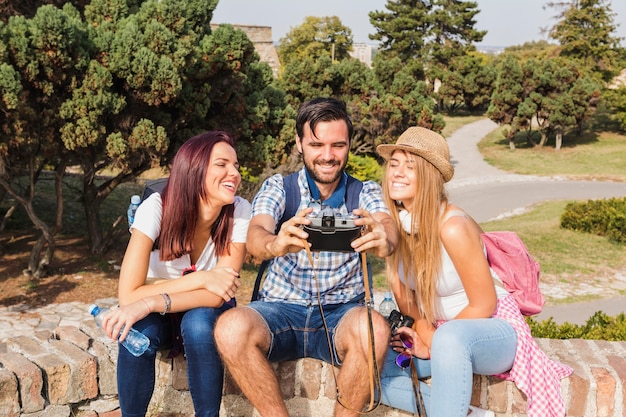 Grupo de amigos felizes tirando foto na câmera