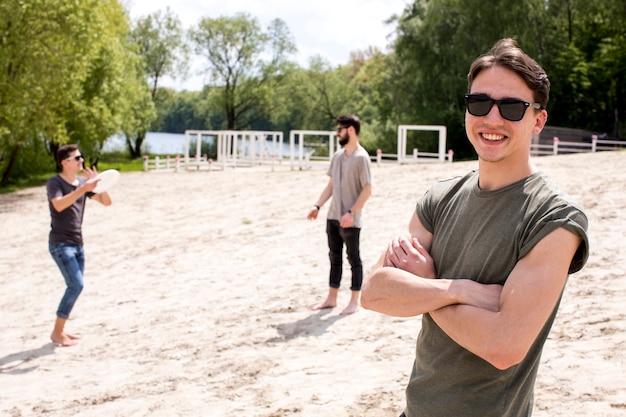 Foto grátis grupo de amigos jogando frisbee na praia