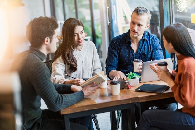 Grupo de amigos multinacionais gosta de conversar com diversão e felicidade conhecendo o conceito de ideias casuais de negócios com fundo de restaurante de café