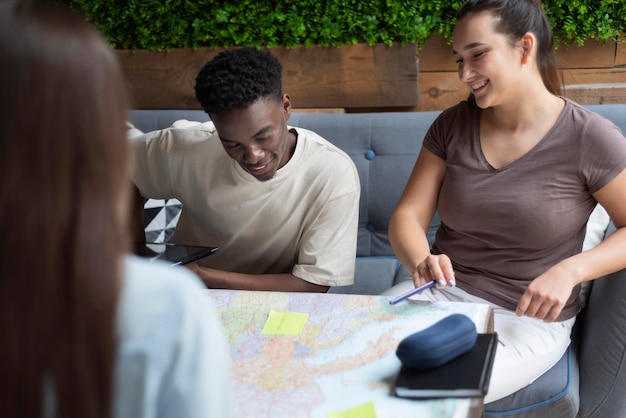 Foto grátis grupo de amigos planejando uma viagem em um café