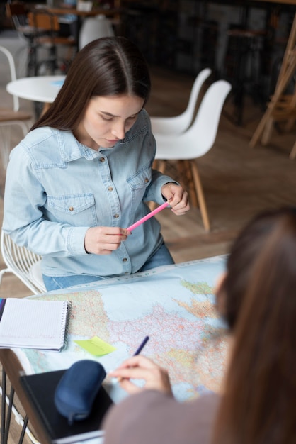 Foto grátis grupo de amigos planejando uma viagem em um café