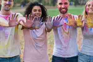 Foto grátis grupo de amigos posando com as mãos coloridas no holi