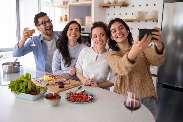 Grupo de amigos tirando uma selfie na cozinha