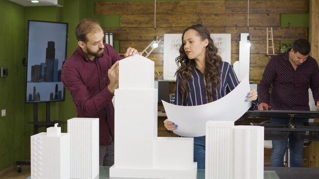 Grupo de arquitetos trabalhando em modelos impressos em 3D de edifícios. Arquitetura e design