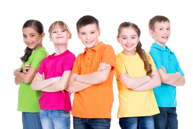 Grupo de crianças sorridentes com os braços cruzados em camisetas coloridas que estão juntos no fundo branco.