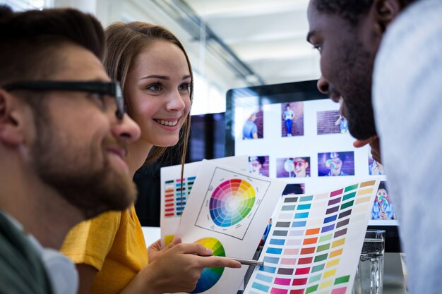 Grupo de designers gráficos que escolhem a cor de uma cartela de cores