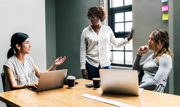 Grupo de diversas mulheres, tendo uma reunião de negócios