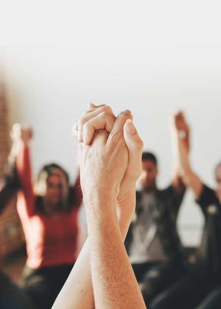 Grupo de diversas pessoas de mãos erguidas no ar