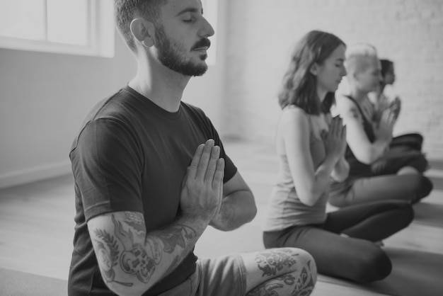 Grupo de diversas pessoas estão se juntando a uma aula de ioga