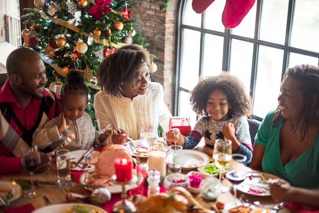 Grupo de diversas pessoas estão se reunindo para o feriado de Natal