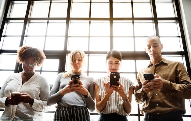 Foto grátis grupo de diversas pessoas usando smartphones