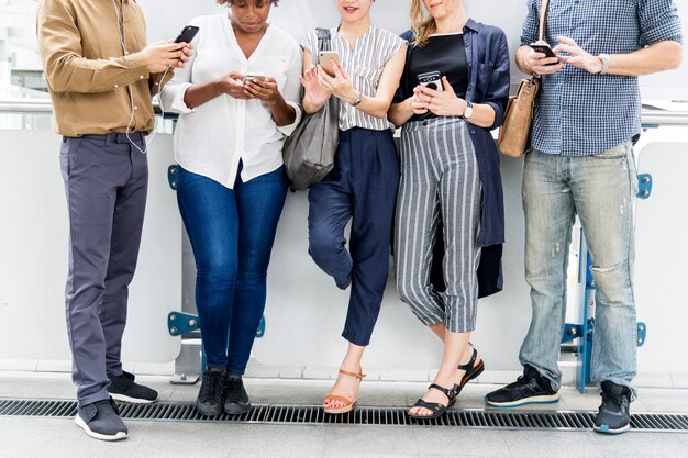 Grupo de diversas pessoas usando smartphones