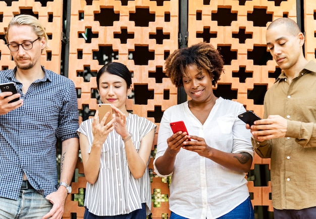 Foto grátis grupo de diversas pessoas usando smartphones