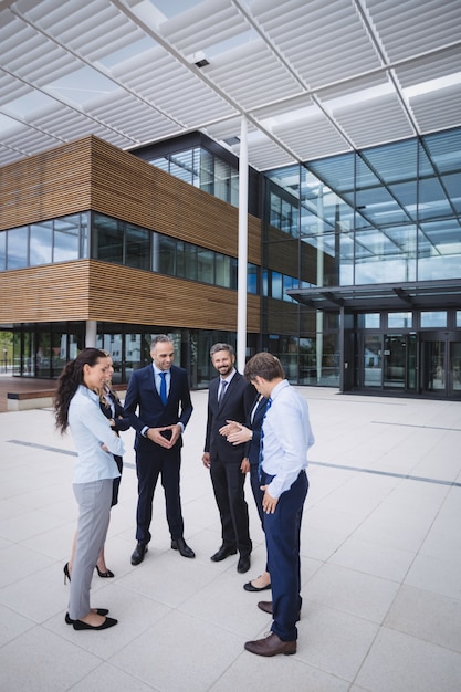 Foto grátis grupo de empresários interagindo fora do prédio de escritórios