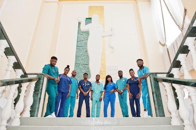 Grupo de estudantes de medicina africanos na faculdade em pé nas escadas