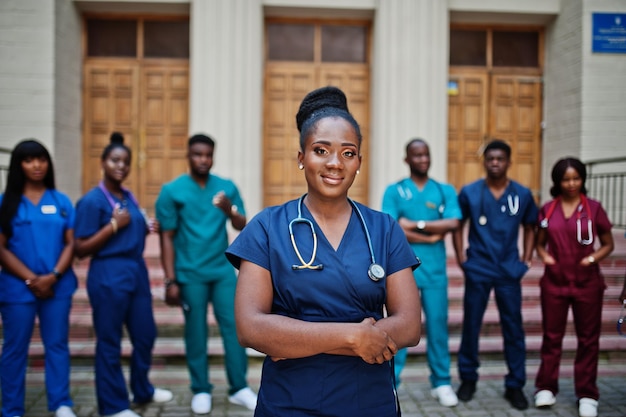 Grupo de estudantes de medicina africanos posou ao ar livre contra a porta da universidade