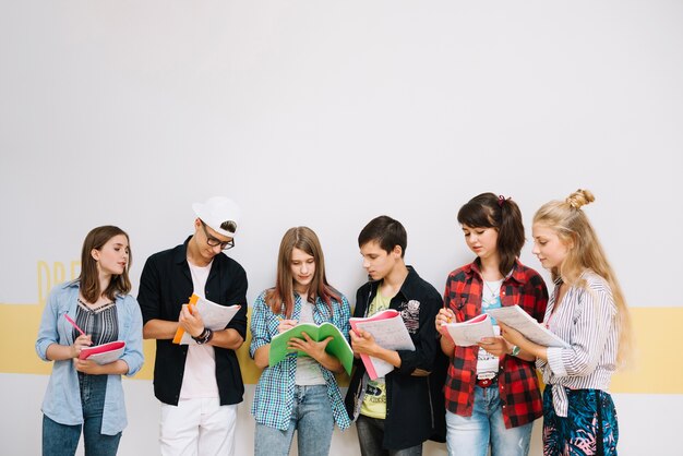 Grupo de estudantes que levantam blocos de notas