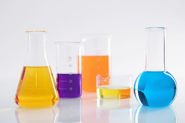 Grupo de frascos diferentes com líquidos coloridos em uma superfície branca em um laboratório