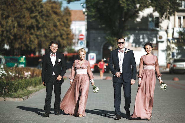 Grupo de groomsmen e madrinhas sorridentes andando