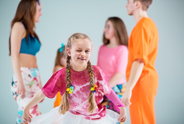 Grupo de homem, mulher e adolescentes dançando coreografia hip hop