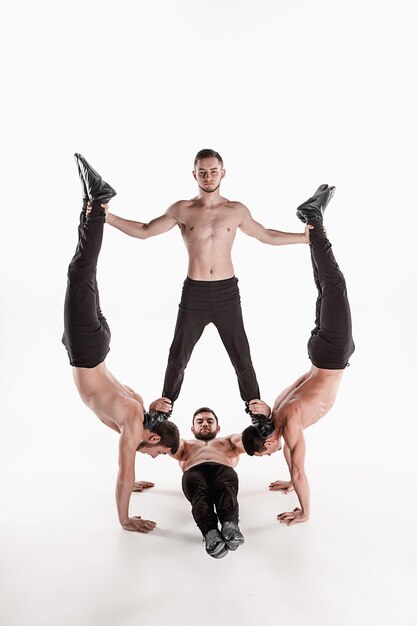 grupo de homens caucasianos acrobáticos ginásticos na pose de equilíbrio