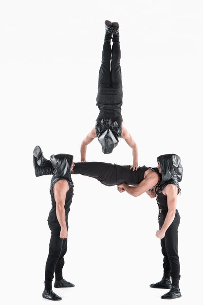 grupo de homens caucasianos acrobáticos ginásticos na pose de equilíbrio