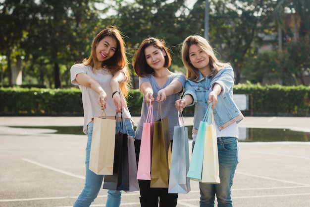 Grupo, de, jovem, mulher asian, shopping, em, um, mercado ao ar livre, com, bolsas para compras, em, seu, mãos