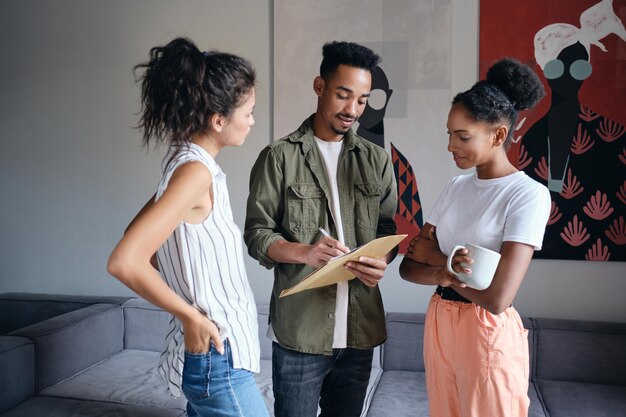 Grupo de jovens casuais multinacionais atraentes trabalhando juntos em um novo projeto no espaço de coworking moderno