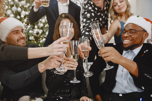 Grupo de jovens comemorando o ano novo. Amigos bebem champanhe.