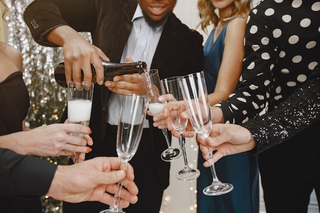 Grupo de jovens comemorando o ano novo. Amigos bebem champanhe.