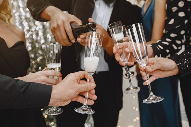 Grupo de jovens comemorando o ano novo. Amigos bebem champanhe.