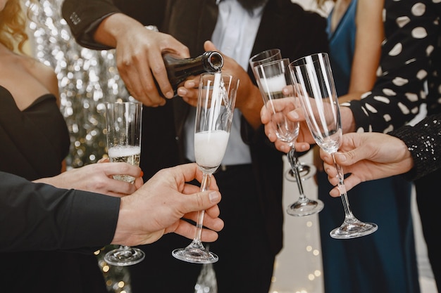 Grupo de jovens comemorando o ano novo. Amigos bebem champanhe.