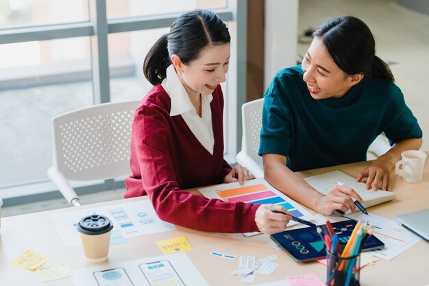 Grupo de jovens criativos da Ásia, supervisor do chefe feminino japonês, estagiário de ensino ou nova funcionária hispânica, ajudando com difícil atribuição no escritório moderno. Conceito de trabalho em equipe do colega de trabalho.