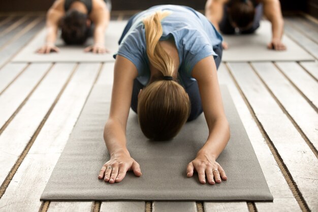 Grupo de jovens em pose de Balasana