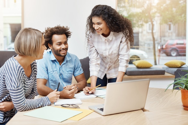 Grupo de jovens empresários passando manhã produtiva na biblioteca, discutindo planos de negócios e desenvolvendo a estratégia da empresa. Conceito de negócios