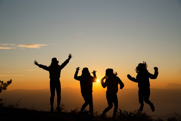 Grupo de jovens felizes pulando na colina. Mulheres jovens, desfrutando