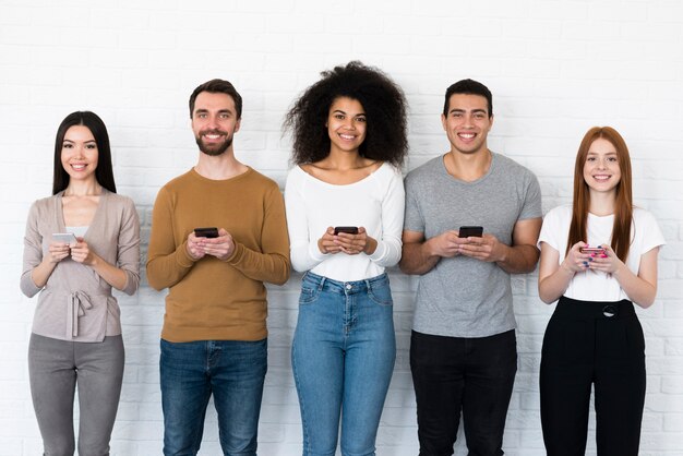 Grupo de jovens segurando seus telefones móveis