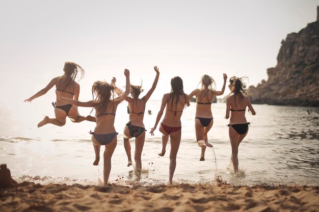 grupo de meninas correr na praia