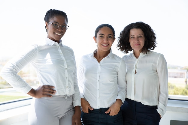 Grupo de mulheres de negócios alegres sorrindo para a câmera