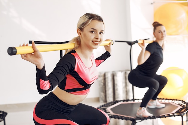 Grupo de mulheres na cama elástica esportiva. Treino de fitness.