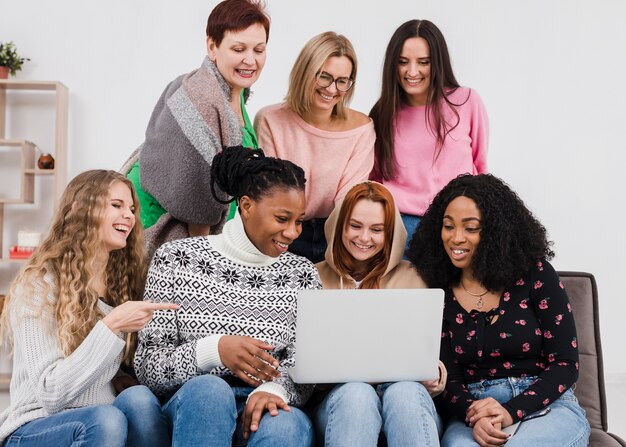 Grupo de mulheres olhando através de um laptop